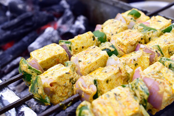 Closeup of marinated paneer tikka at barbeque