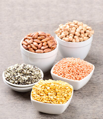 Raw lentils and legumes beans in bowl on table