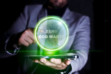 Close up of a businessman pointing to a bubble with the earth icon and Zero Eco Waste text on his cell phone. Environmental care concept