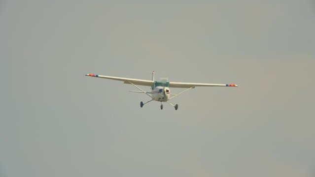 Small aircraft flying over airport. Recreational pilot flight training. Small private single engine airplane at Municipal Airport.