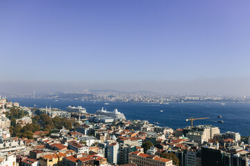 Fototapeta premium Beautiful landscape over city rooftops, bay and city in the background. View of the Bosphorus and Istanbul from the Galata Tower. Istanbul, Türkiye – October 15, 2023