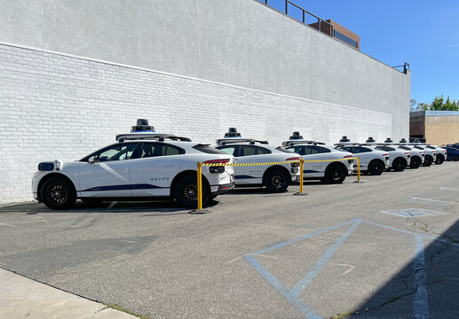 A row of Google Waymo self-driving vehicles at a test facility in West Los Angeles.