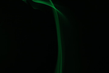 Obraz premium Green lines, green smoke on a dark background, colourful abstract, green fog, minimalism, line of light