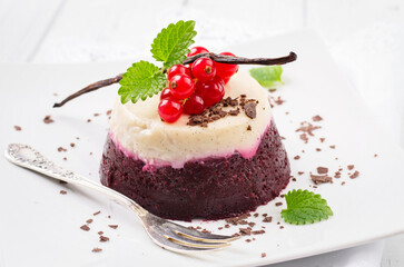 Traditional Italian  currant pudding with chocolate crumbles served as close-up on a classic design plate