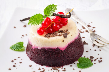 Traditional Italian  currant pudding with chocolate crumbles served as close-up on a classic design plate