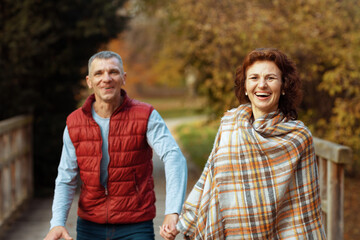 smiling stylish boyfriend and girlfriend in park walking