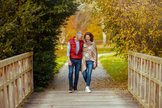 Full length portrait of smiling stylish couple in park walking - Powered by Adobe