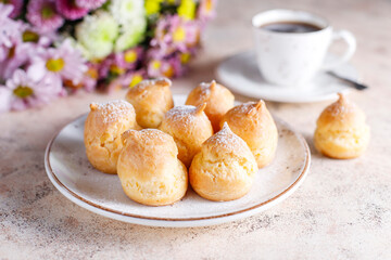 Homemade profiteroles with powdered sugar.