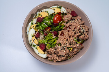 tuna salad with lettuce and eggs in a plate on a white background