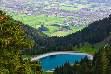Naklejka na ściany i meble Aerial drone view turquoise lake in mountains Bavarian Alps. Ski resort in summer.