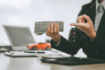 Pretty Asian businesswoman confidently handling funds for new vehicle loan, depicting financial independence and pursuit of luxury, success, modern transportation. lending money on new car loan - obrazy, fototapety, plakaty