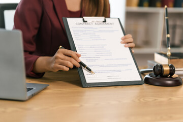 Young Asian female lawyer people reviewing legal documents at desk, embodying reliability, dedication in legal profession, reading announcement. Court convicting defendant according to criminal law