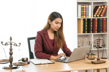 Young Asian female lawyer people reviewing legal documents at desk, embodying reliability,...