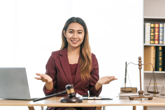 Young Asian female lawyer people reviewing legal documents at desk, embodying reliability, dedication in legal profession, reading announcement. Court convicting defendant according to criminal law