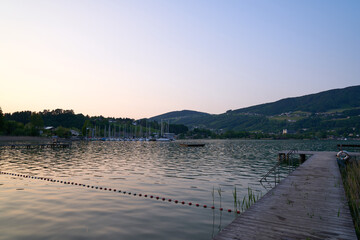 Lake Mondsee in Alps mountains, Austria. Beautiful sunset landscape, with boats and Pier. 