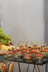 Eating at the event. Disposable plastic cups with snacks - salmon with olive and microgreens.