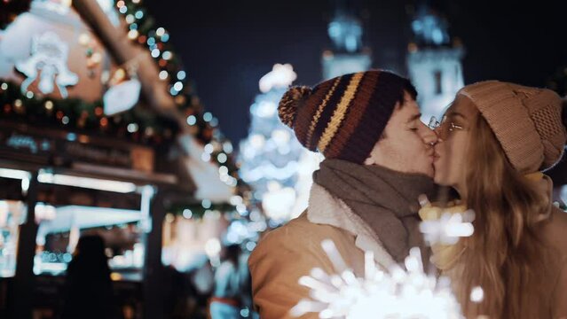Beautiful couple having fun with sparklers outdoor celebrating merry Christmas xmas and happy new year. Young man and woman on date smiling waving firework express joy happiness. Christmas holiday