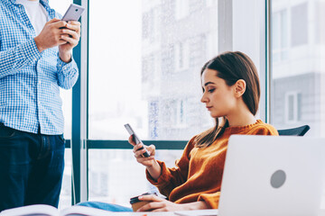 Caucasian partners exchanging contacts via application on cellular phones