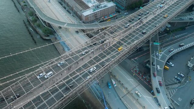 Overhead view above Brooklyn bridge above S street viaduct on Manhattan, NYC USA. Busy traffic in American city background 4K aerial. Scenic rush hour with cars and people crossing Brooklyn bridge 