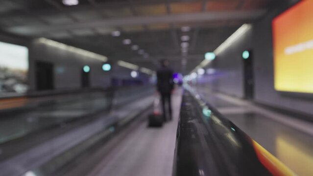 Pilot of plane goes by Moving walkway in airport