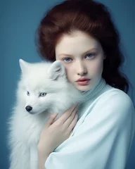 Abstract winter portrait of a beautiful young woman holding a white arctic fox.  © LyubaAlex