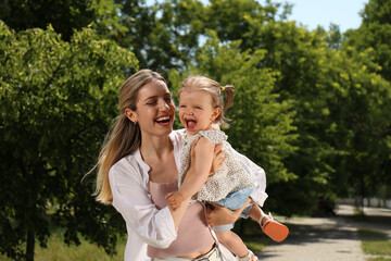 Fototapeta premium Happy mother with her daughter having fun in park. Space for text