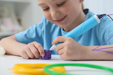 Girl drawing with stylish 3D pen at white table indoors, selective focus