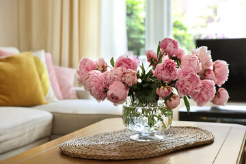 Beautiful pink peonies in vase on table at home, space for text. Interior design