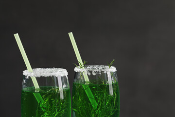 Glasses of homemade refreshing tarragon drink on black background