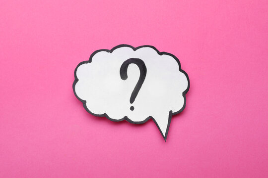 Paper speech bubble with question mark on pink background, top view