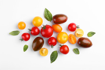 Flat lay composition with different whole and cut tomatoes on white background