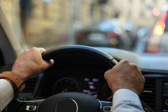 Stuck in traffic jam. Driver holding hands on steering wheel in car, closeup