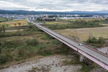 ドローン撮影：信濃川の上にかかる橋と、その上を走る車	