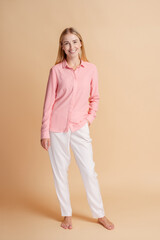 Obraz premium Young woman smiling posing wearing casual clothes on beige background