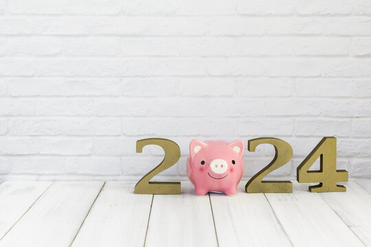 2024 new year and  piggy bank on white wood table over white background with copy space , saving concept