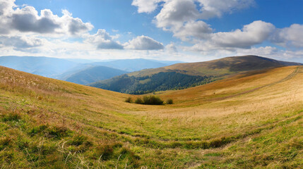 Fototapeta na wymiar landscape with grassy meadows distant mountain beneath a sky with clouds beautiful panoramic scenery of carpathian countryside on a sunny day in early autumn