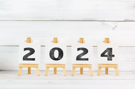 Upcoming 2024 New Year with Art Board over white wood background.