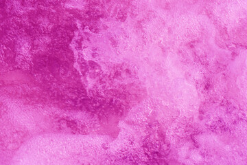 Purple water bubbles with ripples on the surface. Transparent pink colored clear calm water surface texture with splashes and bubbles. Water waves with shining pattern texture background.