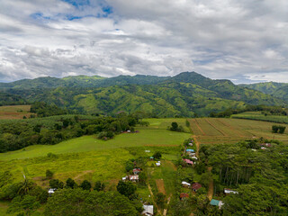 Fototapeta na wymiar Mountain hill with rainforest and agricultural land of farmers. Mindanao, Philippines.