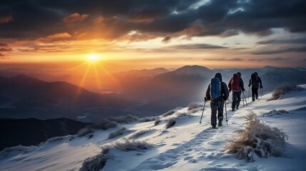 Silhouettes of skiers descending the evening slope
