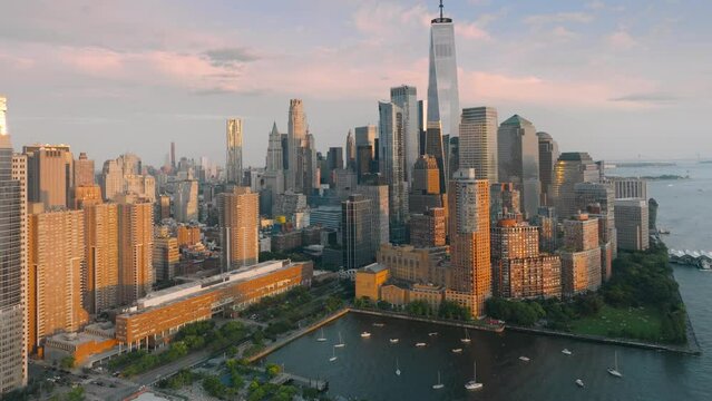 Epic aerial of New York with scenic modern skyscrapers and pink clouds on motion background. Rockefeller park USA. Breathtaking panorama of Financial district on lower Manhattan during golden sunset