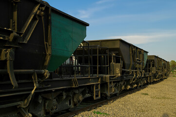 Fototapeta na wymiar Train cars carrying iron ore are lined up on the tracks waiting to be loaded