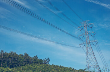 High voltage pole electric wiring distribution landscape energy engineering. Electricity energetic background with blue sky green mountain in countryside. Electric power energy engineering industrial