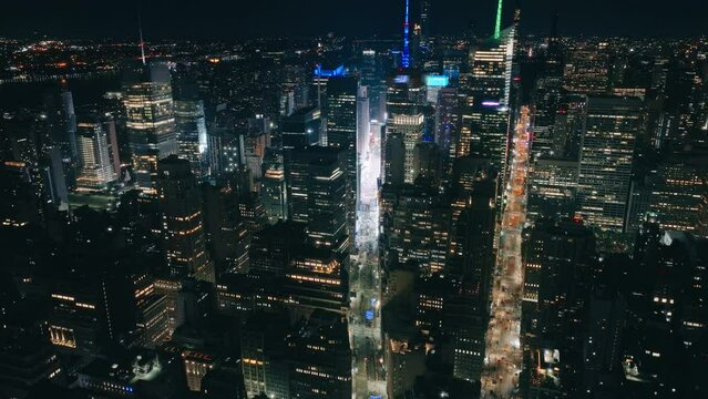 Aerial helicopter overhead top down view of Times Square at night. Establishing shot of colorfully illuminated world famous tourist attraction on Manhattan, New York City. Epic USA city downtown 4K