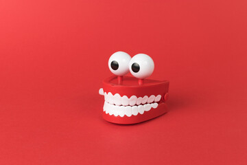 Wind-up toy mouth and eyes on a red background.
