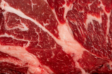 Close-up beef raw red steak on wooden board background.Meat texture.