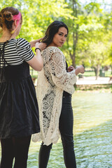 The beauty of preparation: a make-up artist getting a beautiful and young brunette model ready for a photoshoot in a park	