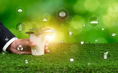 Businessman holding green plant with eco digital design icon symbolize environmental friendly...