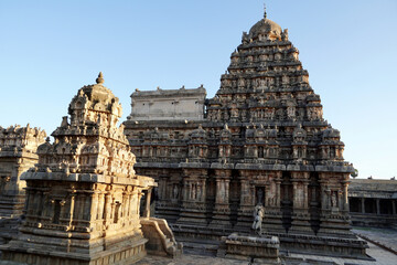 Naklejka premium Tower of Airavatesvara Temple, Darasuram, Kumbakonam, Tamilnadu. Ancient hindu temple tower with carvings of God sculpture isolated against blue sky background in Tamilnadu.