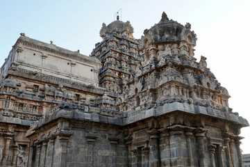 Fototapeta premium Tower of Airavatesvara Temple, Darasuram, Kumbakonam, Tamilnadu. Ancient hindu temple tower with carvings of God sculpture isolated against blue sky background in Tamilnadu.